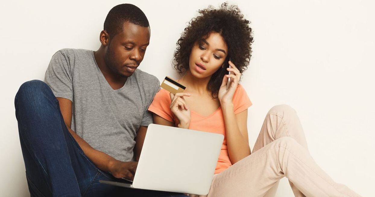 girl and guy at computer with credit card and cell phone